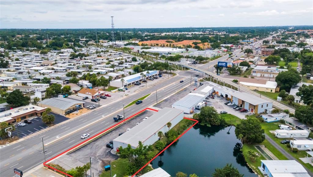 An aerial view shows a commercial building with a parking lot next to a pond — 6581 SEMINOLE BOULEVARD, SEMINOLE, FL