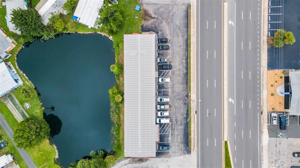 An aerial view shows a long rectangular building beside a pond and a multi-lane road — 6581 SEMINOLE BOULEVARD, SEMINOLE, FL