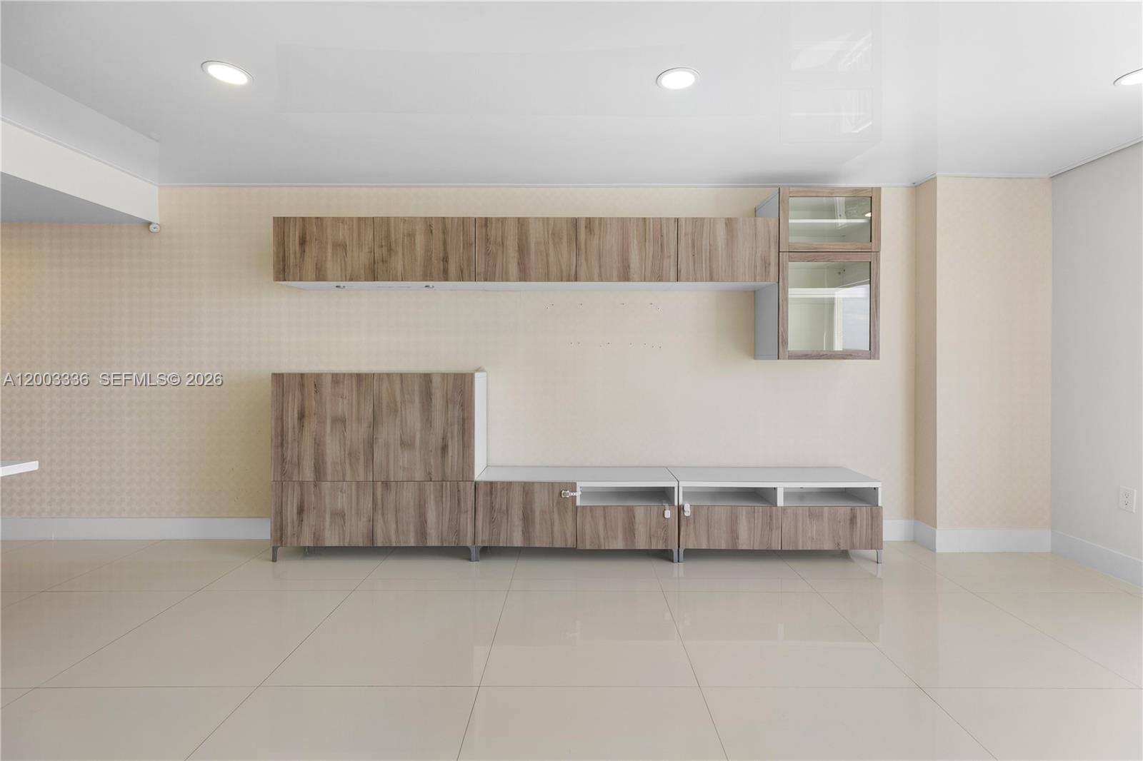 A room features light-colored tile flooring, beige patterned wallpaper, and modern wood-finish cabinetry — 3000 Coral Way # 1110, Miami FL 33145, MIAMI, FL
