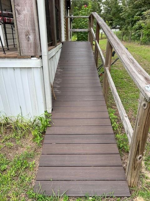 A wooden wheelchair ramp with a handrail leads up to the side of a house — 6850 SE 88 LANE, TRENTON, FL
