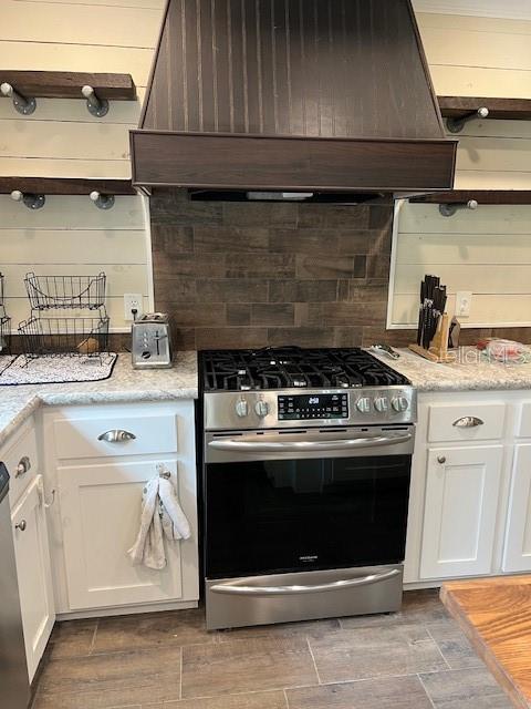 A kitchen features a stainless steel gas range, a dark wood hood, and open shelving — 6850 SE 88 LANE, TRENTON, FL