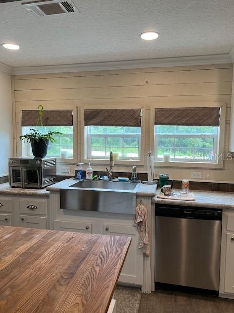 A kitchen features a stainless steel farmhouse sink, white cabinetry, and horizontal wood wall paneling — 6850 SE 88 LANE, TRENTON, FL