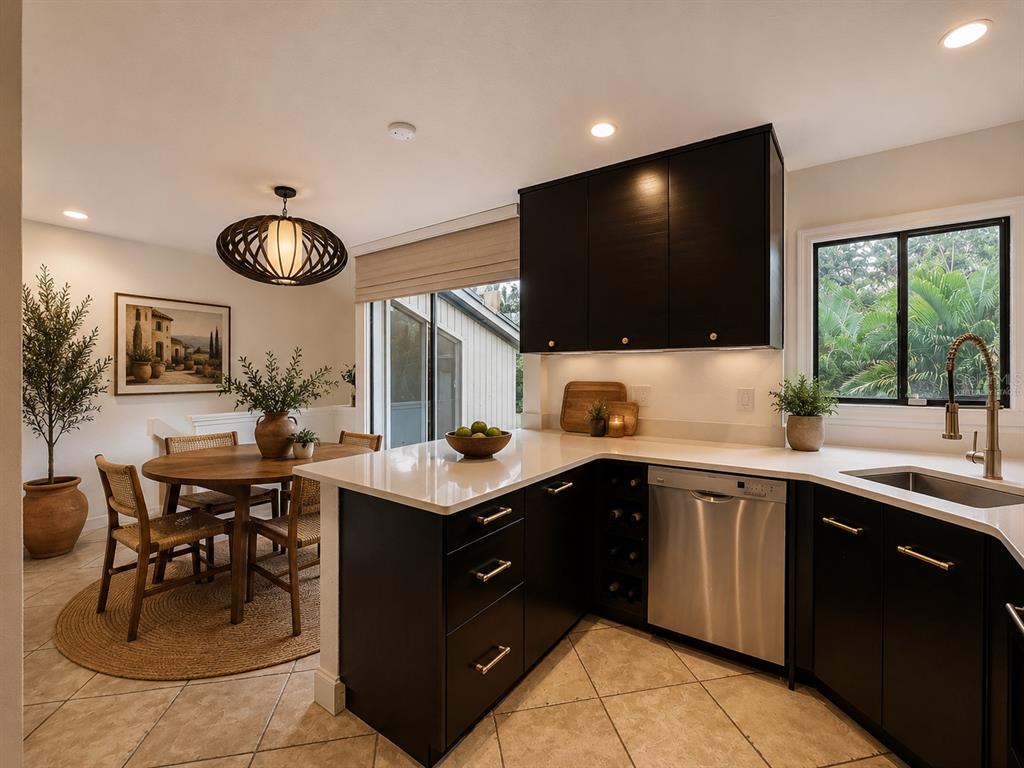 A kitchen with dark cabinets, white countertops, and a dining area with a round table — 542 S OSCEOLA AVENUE UNIT 34, ORLANDO, FL