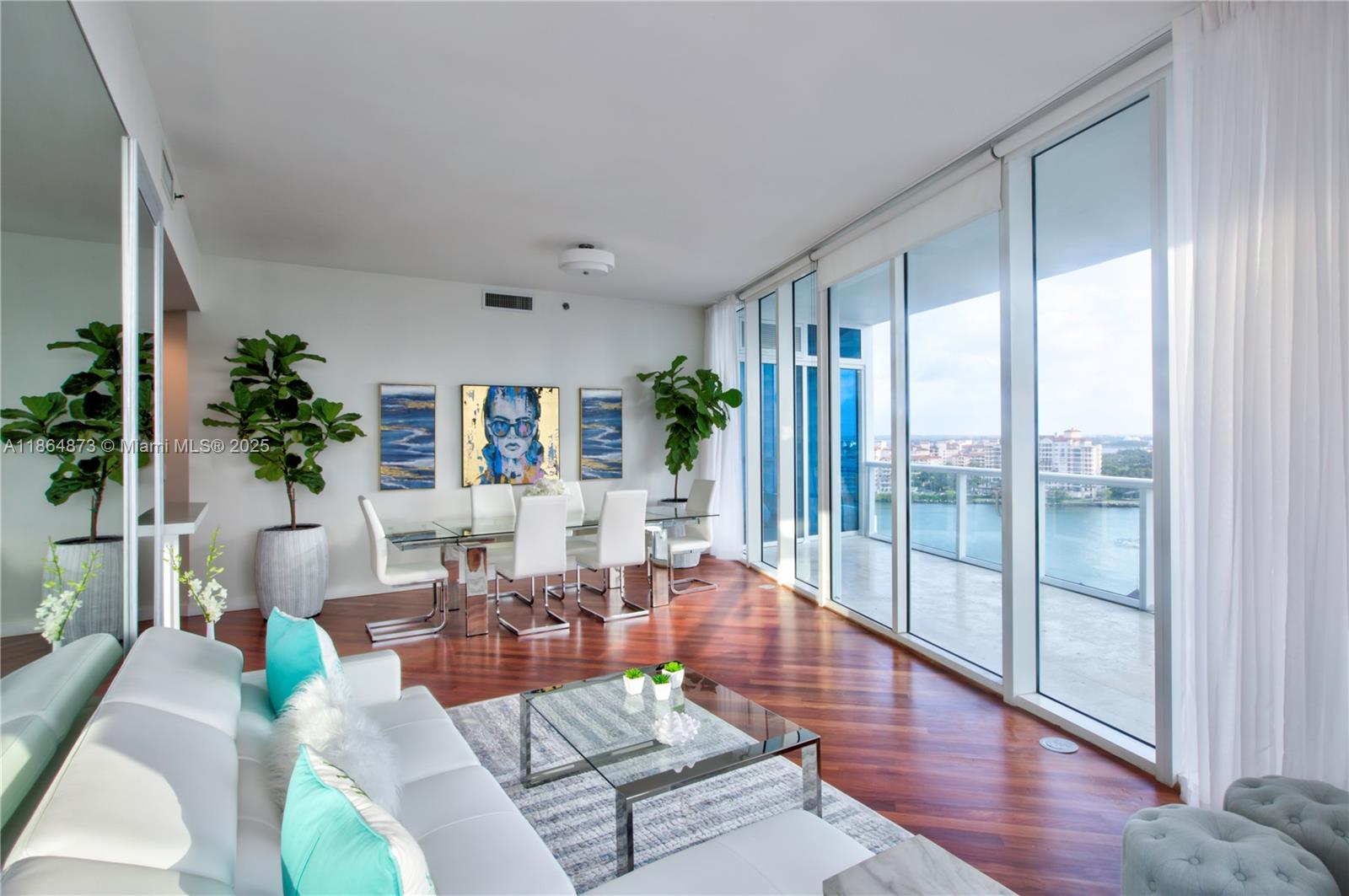 A modern living and dining room features floor-to-ceiling windows with a waterfront balcony view — 100 S Pointe Dr # 1501, Miami Beach FL 33139, MIAMI BEACH, FL