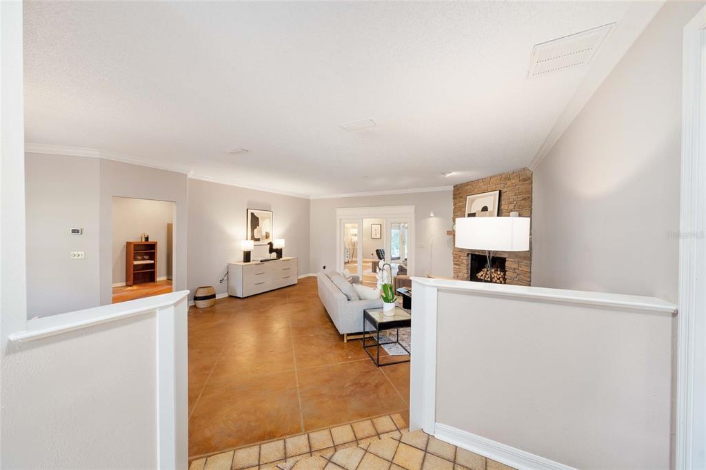 A living room features a stone fireplace, light gray walls, and large brown floor tiles — 8120 NW 48TH LANE, OCALA, FL