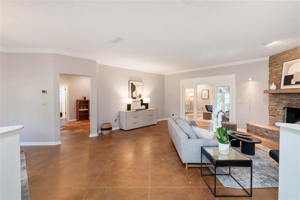 A living room features stained concrete floors, a stone fireplace, and a light gray sofa — 8120 NW 48TH LANE, OCALA, FL