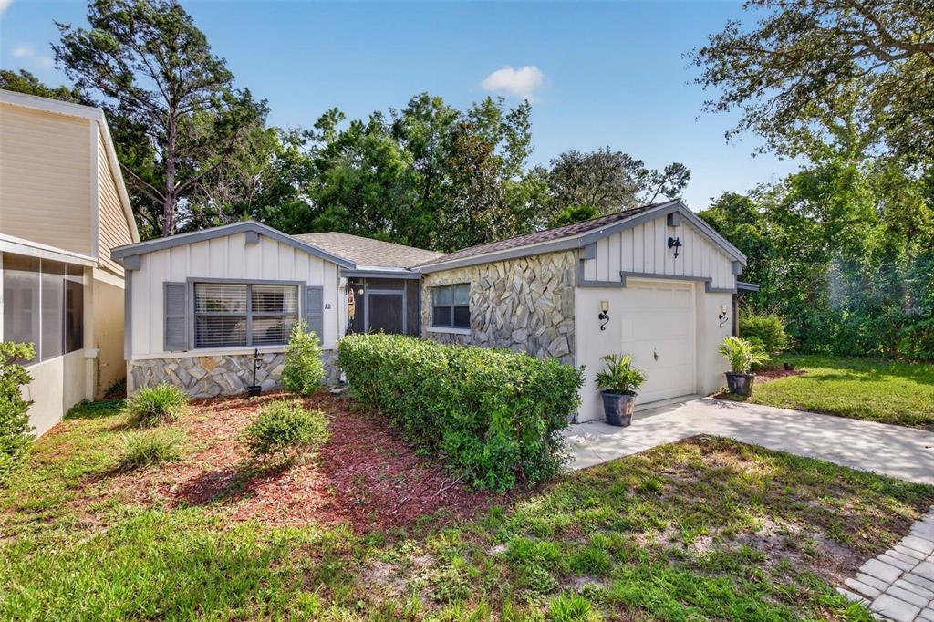 A single-story house with a stone facade, white vertical siding, and a one-car garage — 12 CHINABERRY CIRCLE, HOMOSASSA, FL