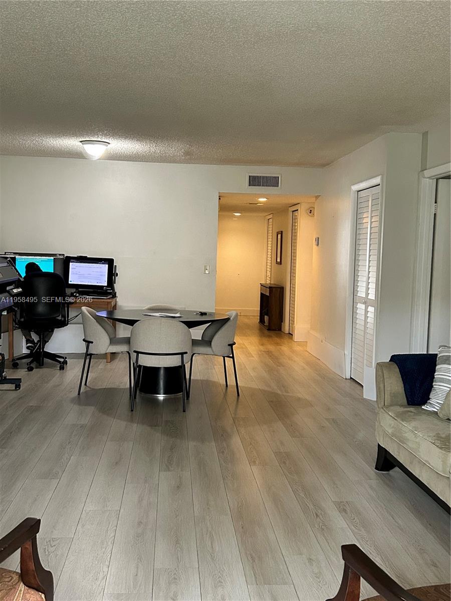 A living area features light wood-look flooring, a dining table, and a computer workspace — 16441 Blatt Blvd # 102, Weston FL 33326, WESTON, FL