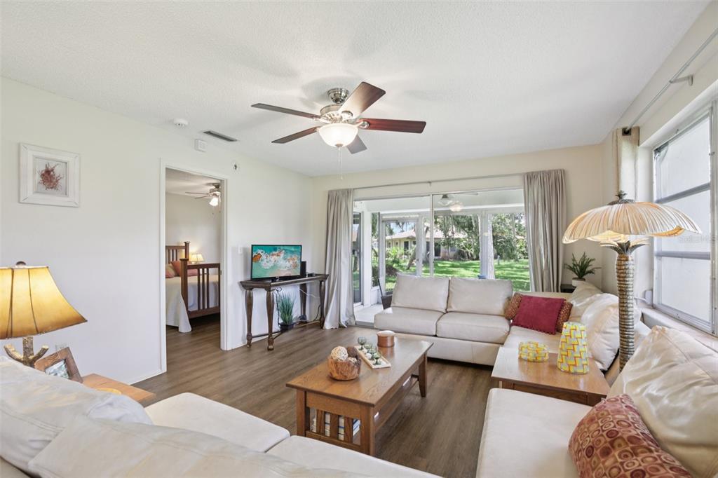 A living room with a sectional sofa, coffee table, and sliding glass doors to a patio — 7172 GREY SQUIRREL BOULEVARD UNIT 81, SARASOTA, FL