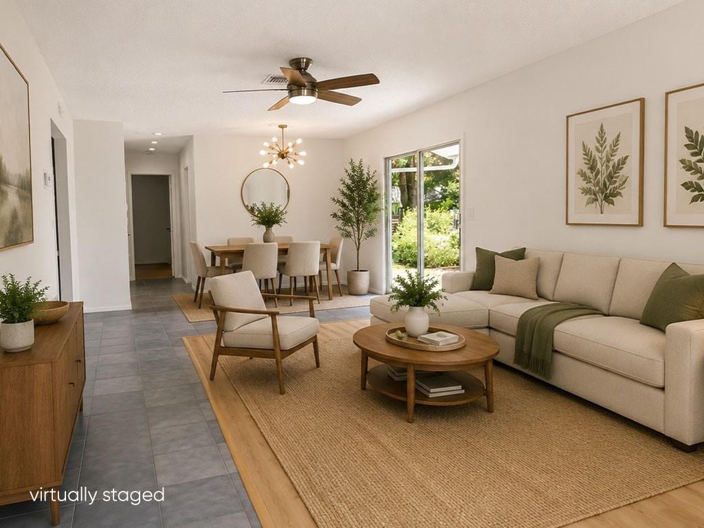 This virtually staged living and dining room features tile and wood flooring and neutral furniture — VERO BEACH, FL
