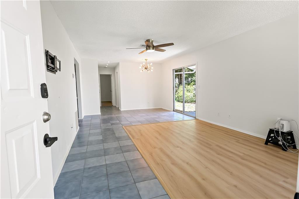 An open-concept living area features a mix of gray tile and light wood-look flooring — VERO BEACH, FL