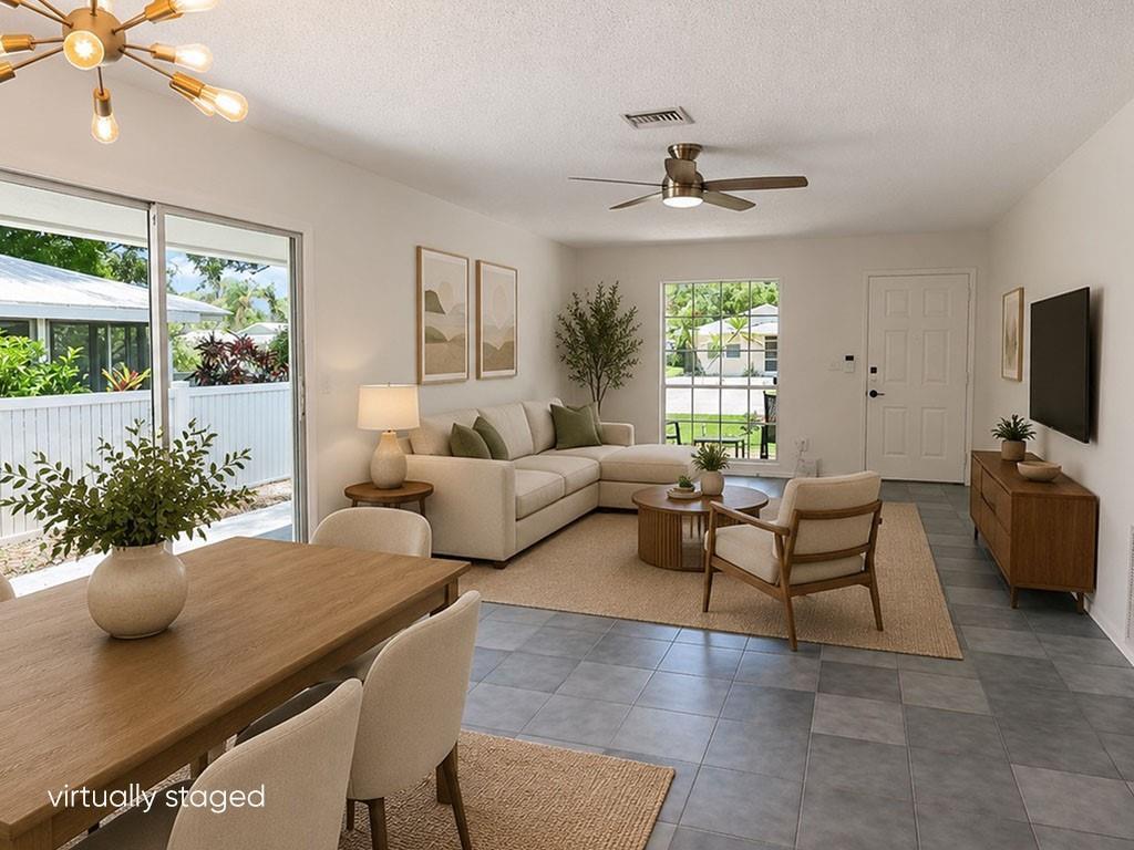 This virtually staged living and dining room features tile flooring, a ceiling fan, and furniture — VERO BEACH, FL