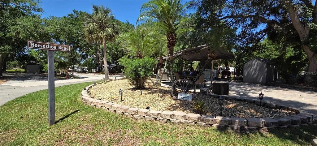A street sign for Horseshoe Bend stands beside a landscaped yard with a patio cover — 185 APPALOOSA TRAIL, RIVER RANCH, FL