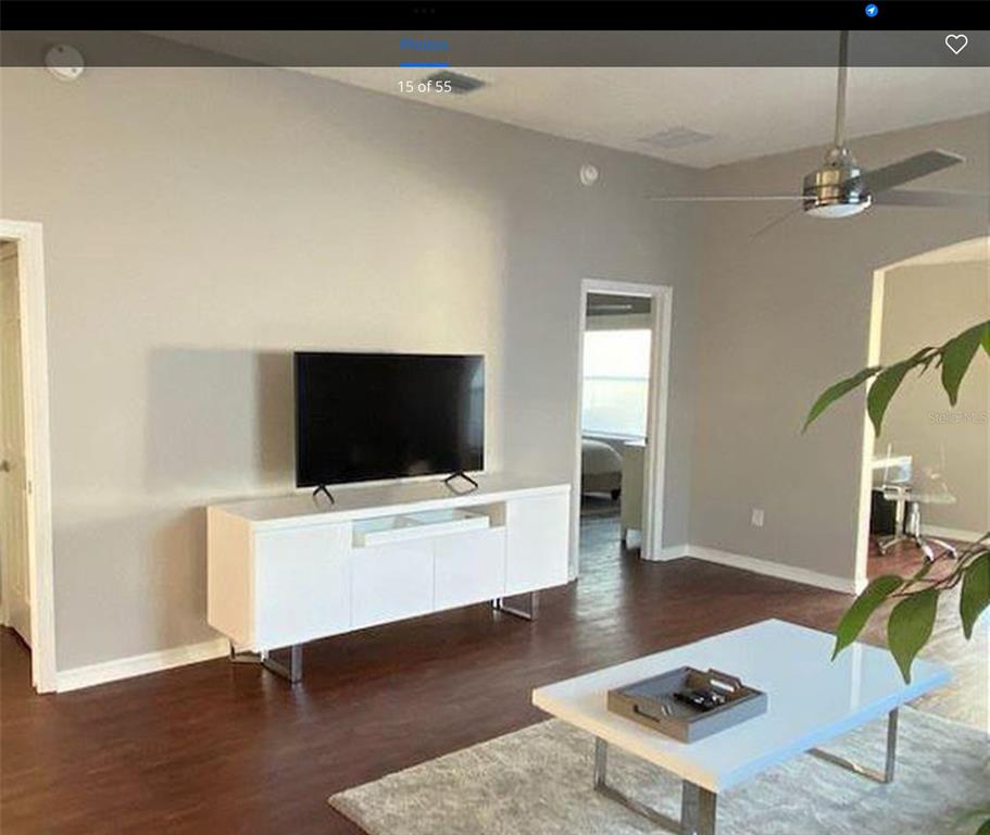 A living room features a white media console, a television, and a white coffee table — 1228 ESTILL AVENUE, THE VILLAGES, FL