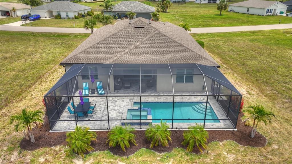An aerial view of a house with a screened-in pool, spa, and patio area — 16283 ALCIRA CIRCLE, PUNTA GORDA, FL