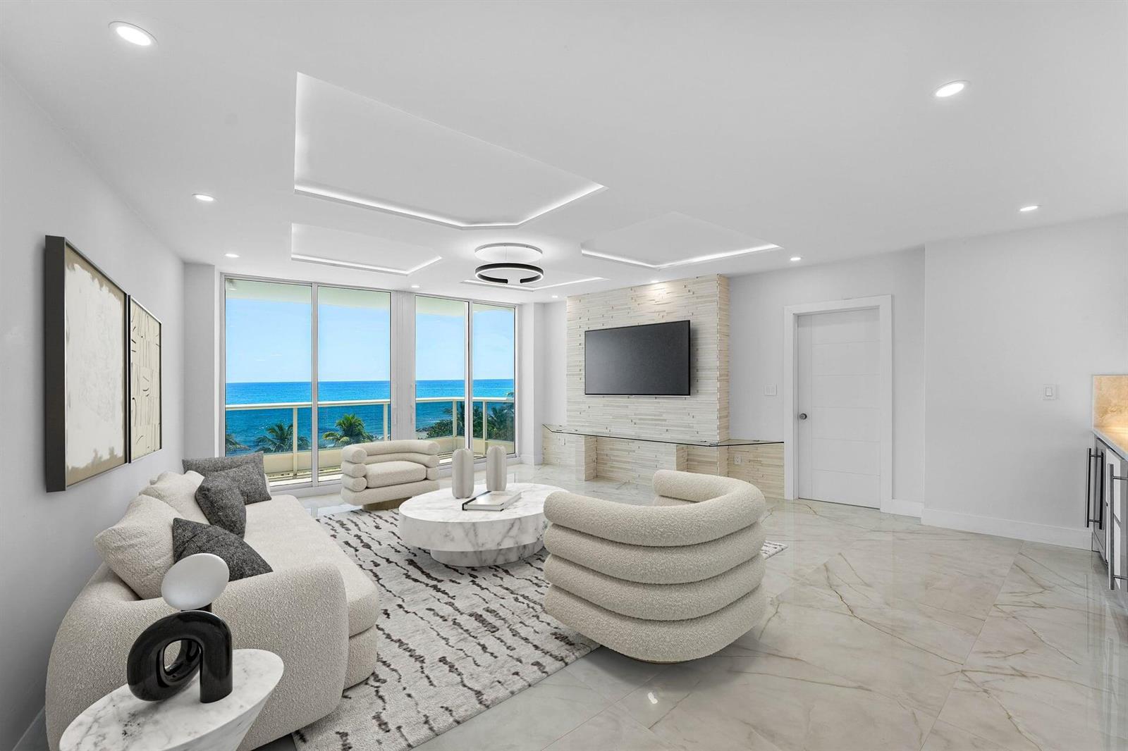 A modern living room features marble floors, a stone accent wall, and ocean views — 700 S Ocean Boulevard # 504, Boca Raton FL 33432, BOCA RATON, FL
