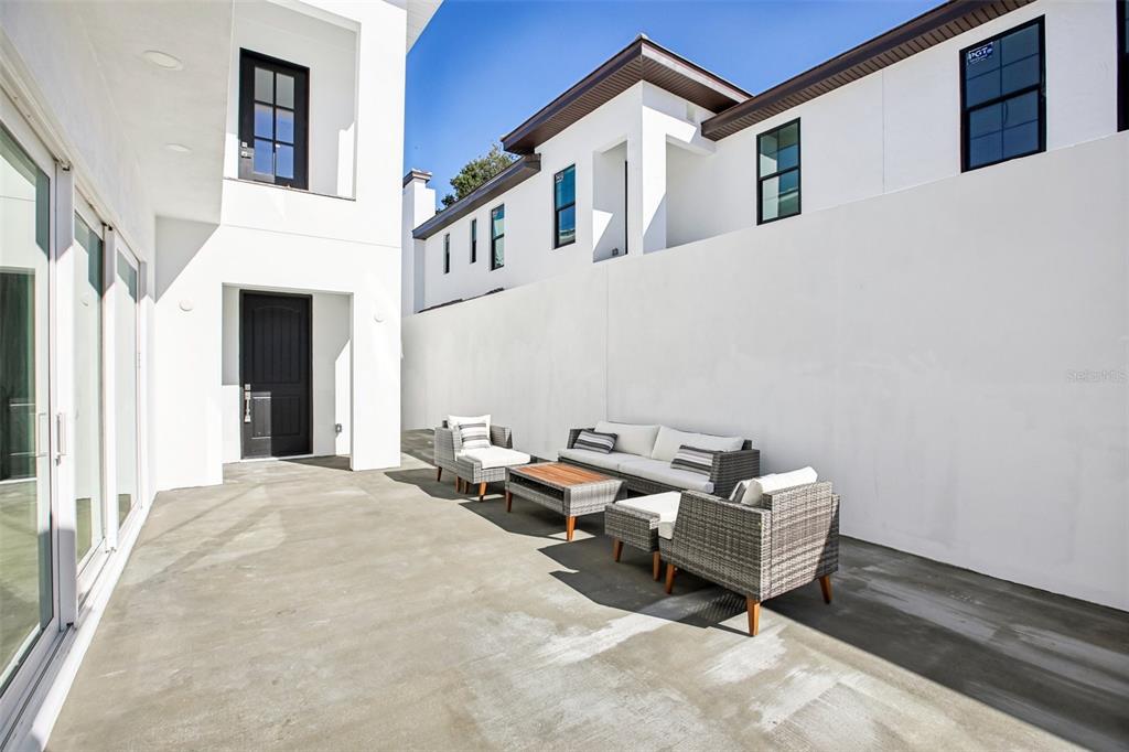 An open-concept living area features light wood flooring, a kitchen with wooden cabinets, and stairs — 126 RICARDO WAY NE, ST PETERSBURG, FL