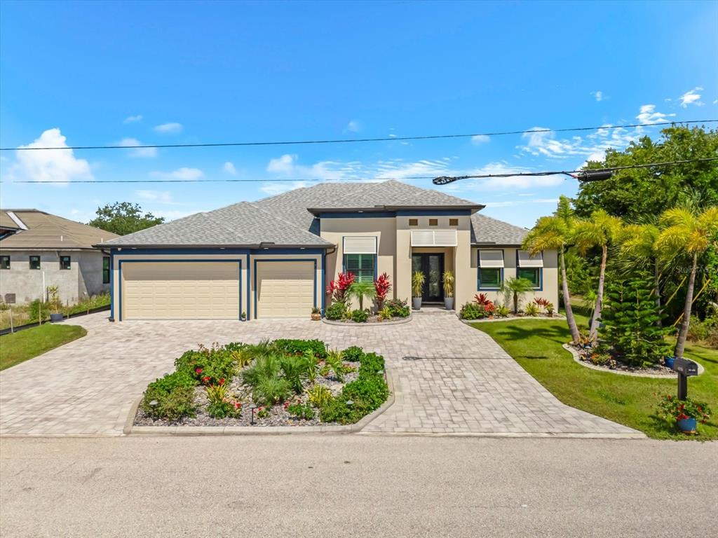 A single-story house with a paved driveway, two-car garage, and landscaped front yard — 13407 CHENILLE DRIVE, PORT CHARLOTTE, FL