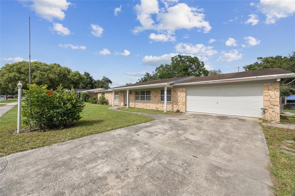 A single-story house with a stone facade, a two-car garage, and a concrete driveway — 409 DEBRA DRIVE, BRANDON, FL
