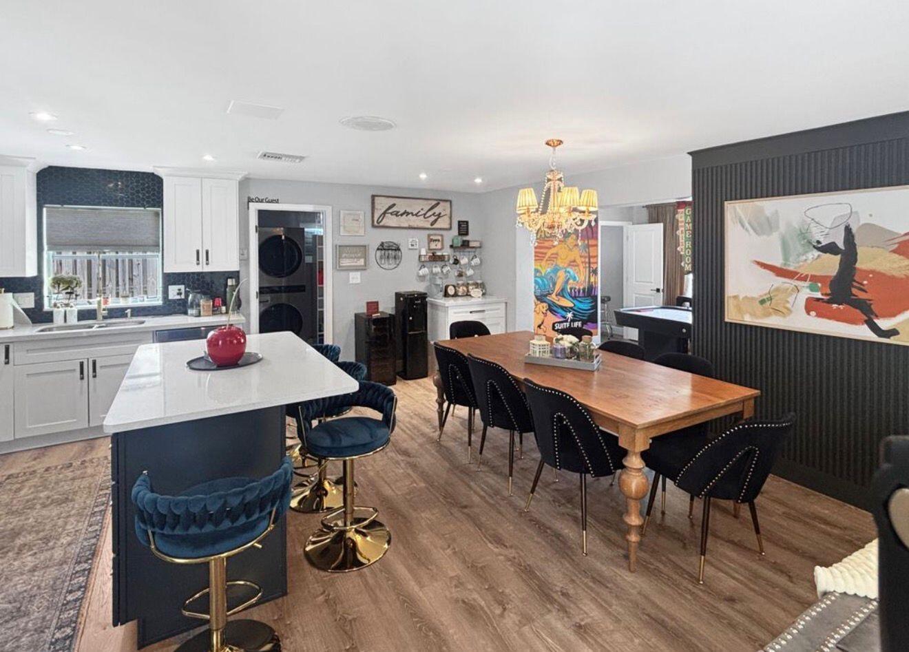 A kitchen and dining area featuring a dark blue island, wooden table, and black chairs — 100 SW 17th Street, Pompano Beach FL 33060, POMPANO BEACH, FL