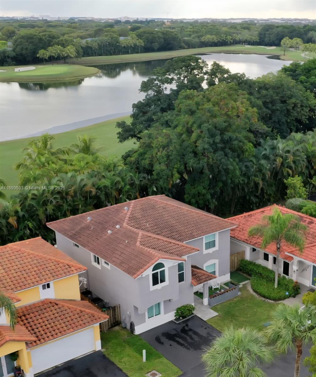 An aerial view shows a two-story gray house with a tiled roof near a lake — 5754 NW 98th Ave, Doral FL 33178, DORAL, FL