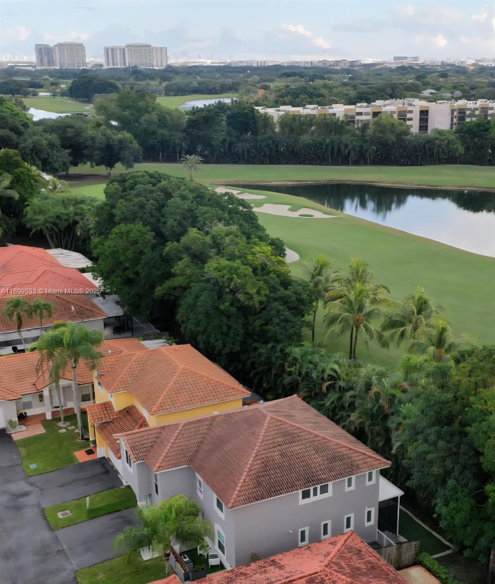 An elevated view shows residential houses with red tile roofs overlooking a golf course lake — 5754 NW 98th Ave, Doral FL 33178, DORAL, FL