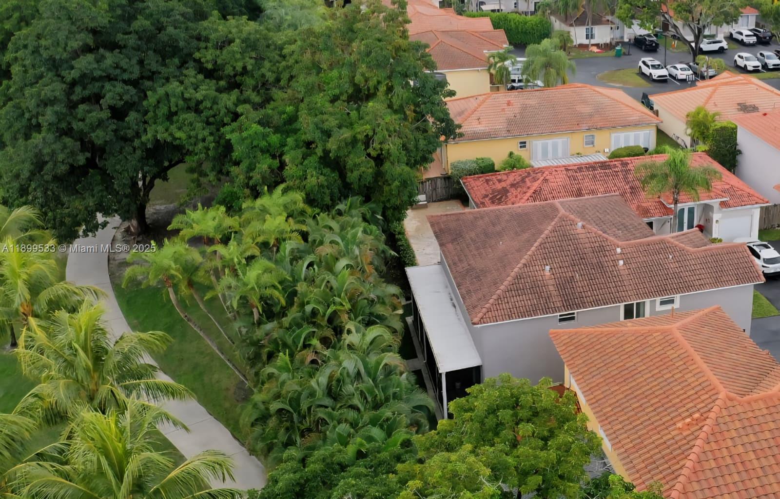 An aerial view shows residential houses with tiled roofs surrounded by lush trees and landscaping — 5754 NW 98th Ave, Doral FL 33178, DORAL, FL
