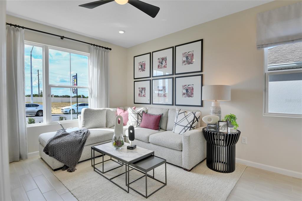 A living room features a sectional sofa, nested coffee tables, and a gallery wall — 14514 BANKS COURT, PARRISH, FL