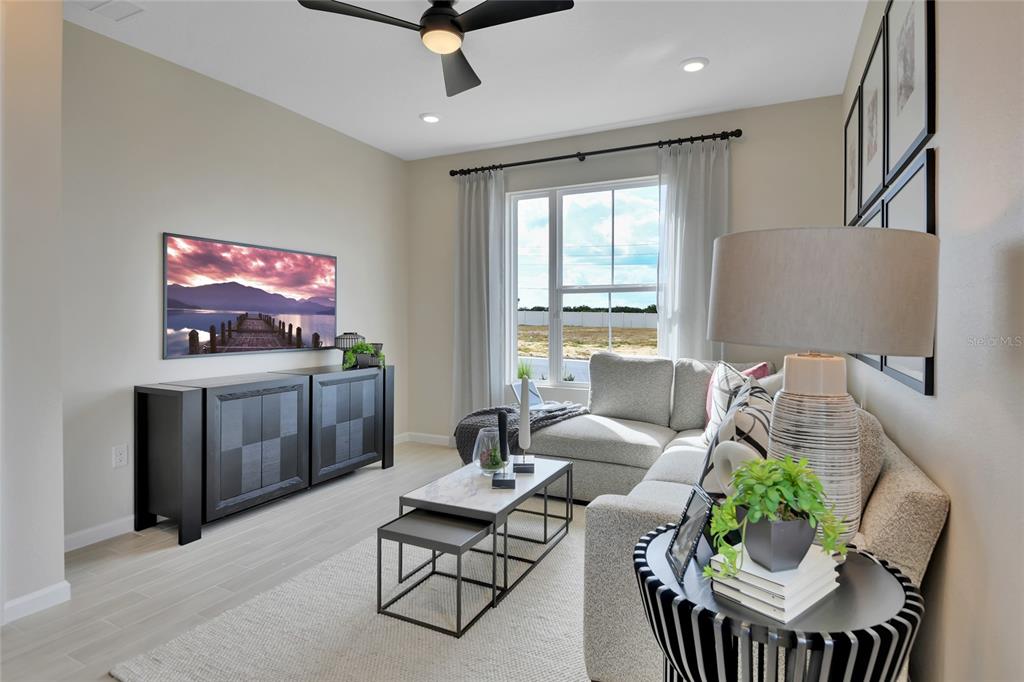 A living room features a sectional sofa, a nested coffee table, and a wall-mounted television — 14514 BANKS COURT, PARRISH, FL