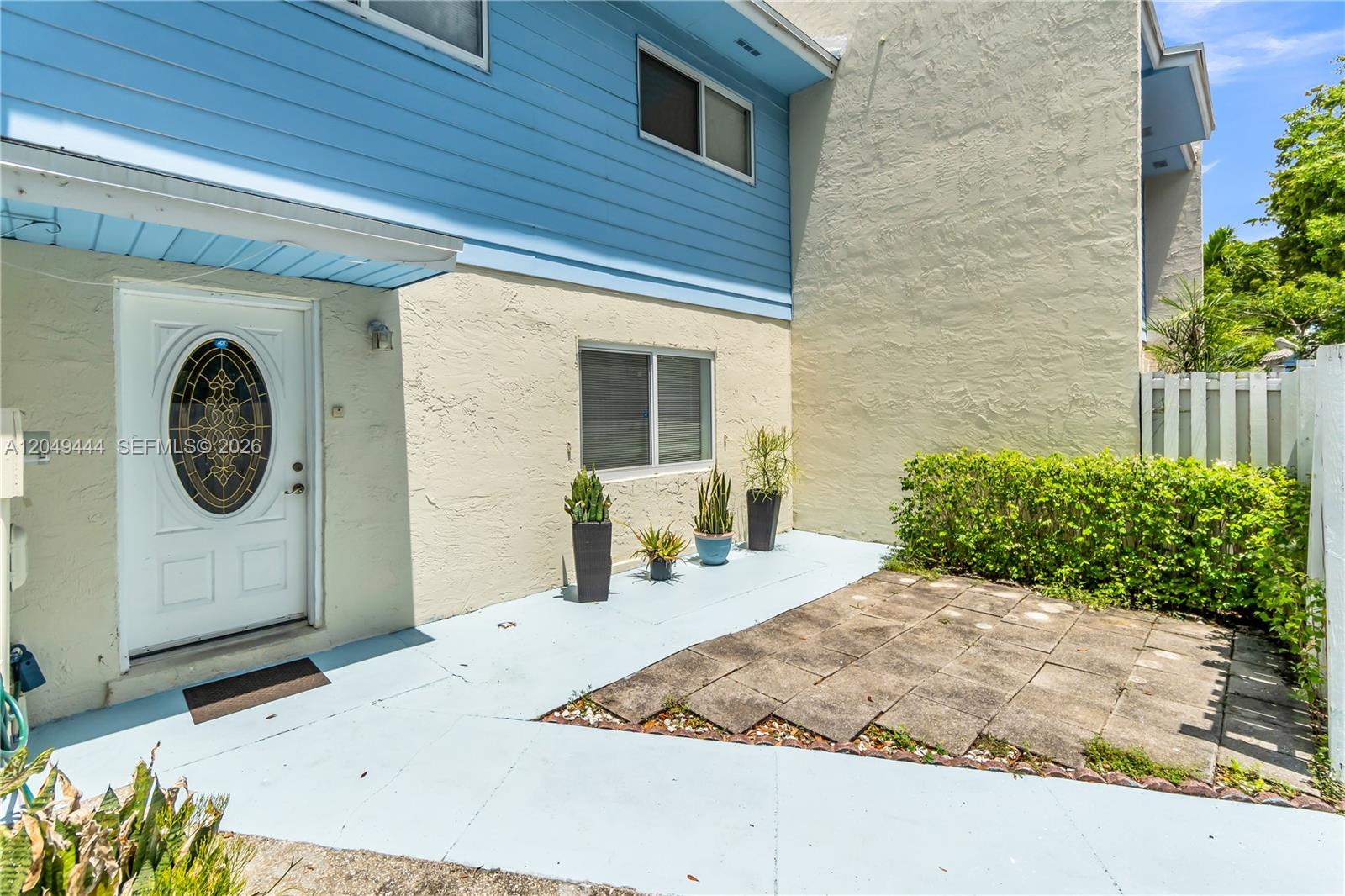 A light blue and beige two-story building exterior features a front door and patio area — 22334 SW 103rd Ct, Cutler Bay FL 33190, CUTLER BAY, FL