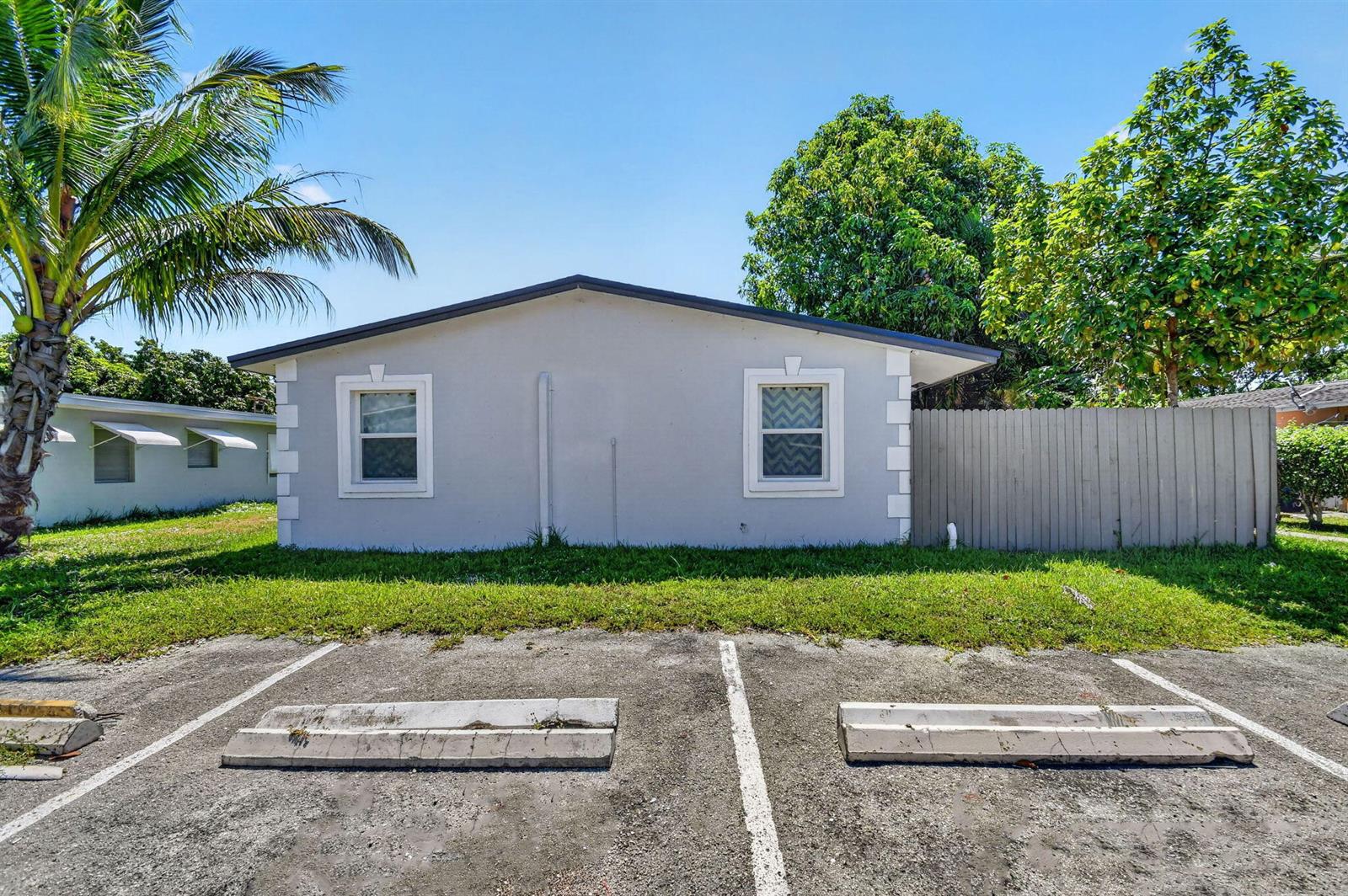 A single-story gray house with two windows and a parking lot in the foreground — 3382 Rudolf Road, Lake Worth FL 33461, LAKE WORTH, FL