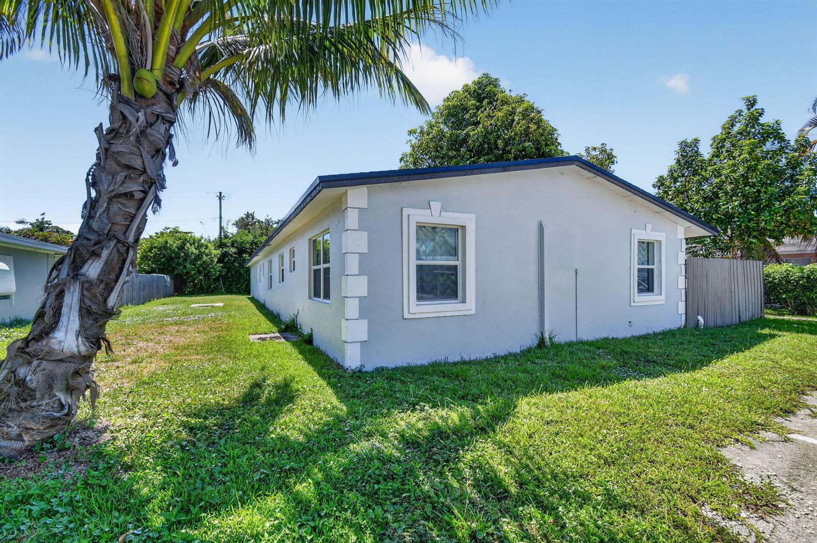 A side view of a light gray single-story house with white corner accents and windows — 3382 Rudolf Road, Lake Worth FL 33461, LAKE WORTH, FL