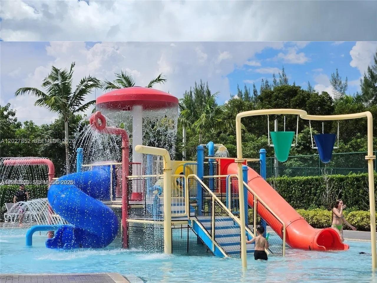 A colorful outdoor water playground features slides, a mushroom fountain, and dumping buckets — 8005 NW 104th Ave # 3, Doral FL 33178, DORAL, FL
