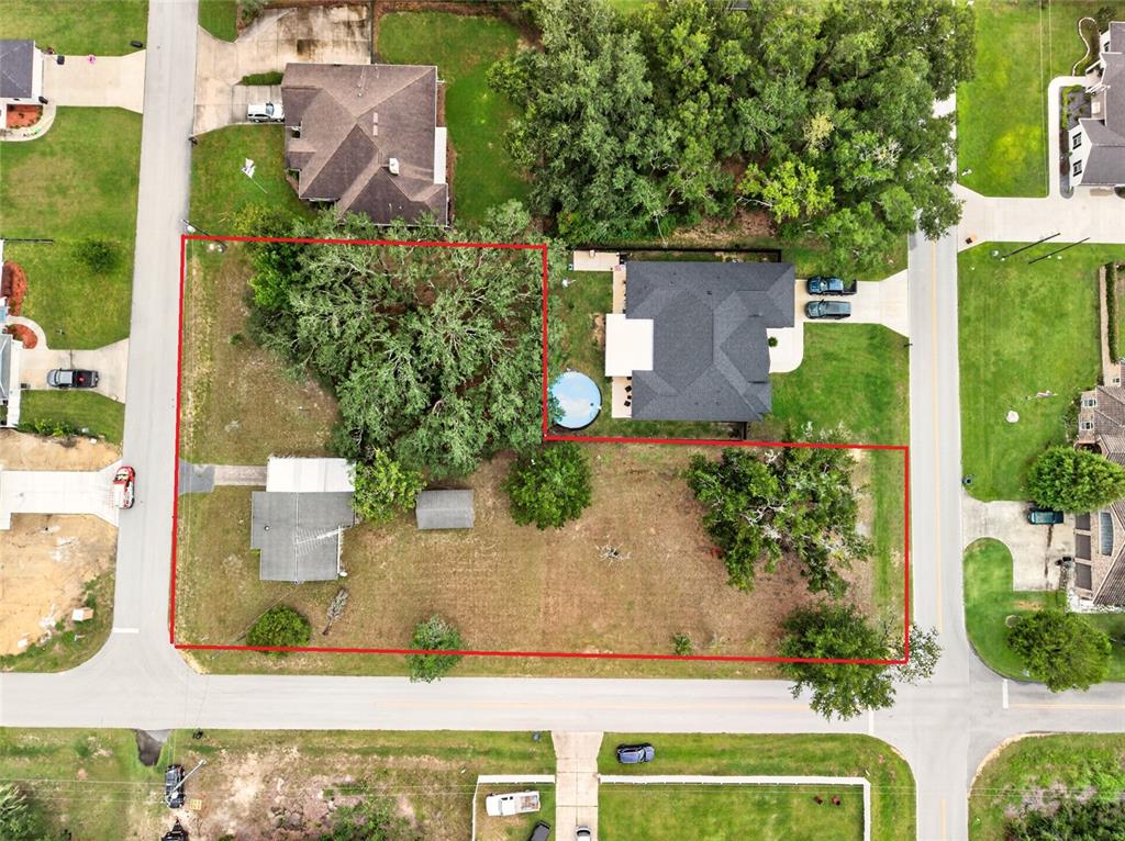 This aerial view shows a residential property lot outlined in red with two houses — 16220 SE 83RD COURT, SUMMERFIELD, FL