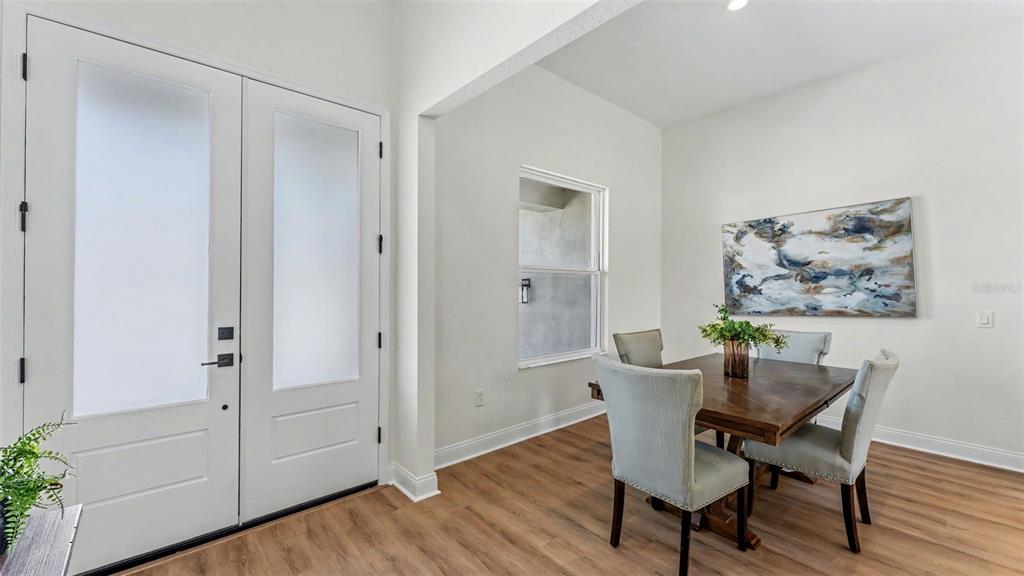 A dining area with a wooden table and chairs sits beside a white double door — 535 SHANKLIN AVENUE, BARTOW, FL