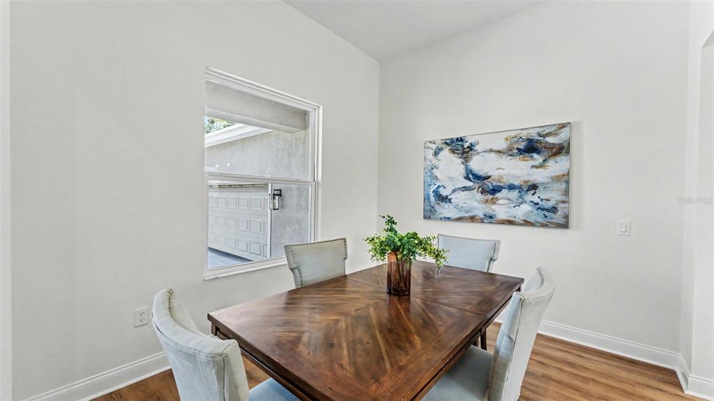 A dining room features a wooden table, four upholstered chairs, a window, and wall art — 535 SHANKLIN AVENUE, BARTOW, FL