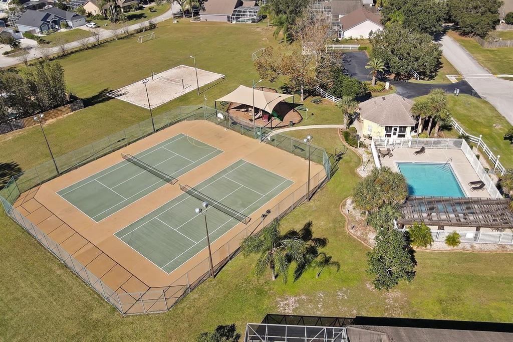 An aerial view of a community recreation area featuring tennis courts, a pool, and playground — 10 NEVADA LOOP ROAD, DAVENPORT, FL