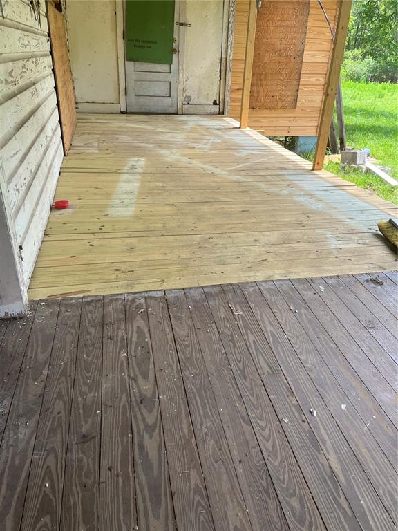 A partially renovated wooden porch features new light-colored decking boards meeting older, weathered planks — 10033 SW COUNTY ROAD 225, STARKE, FL