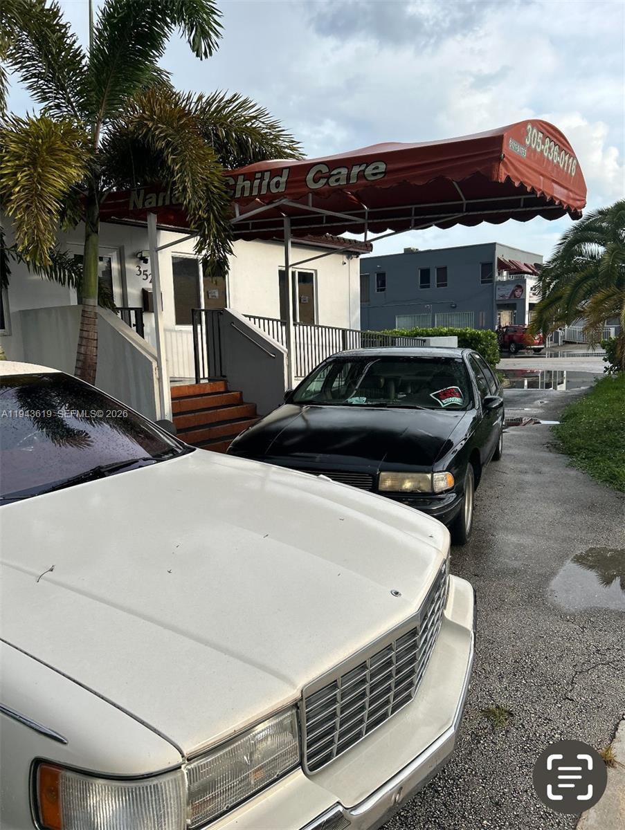 A white car and a black car are parked in front of a child care building — 3521 E 4th Ave, Hialeah FL 33013, HIALEAH, FL