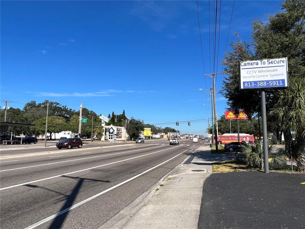 A view of a multi-lane road with a prominent CCTV security sign on the right — 8610 N SUWANEE AVENUE, TAMPA, FL