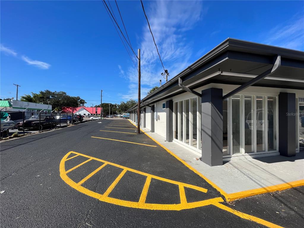 An exterior view of a commercial building with a paved parking lot and yellow markings — 8610 N SUWANEE AVENUE, TAMPA, FL