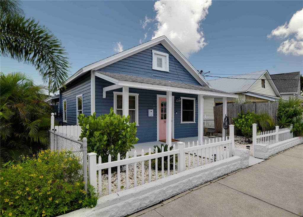 A blue cottage with a white picket fence and a pink front door — 315 HOPE STREET, TARPON SPRINGS, FL