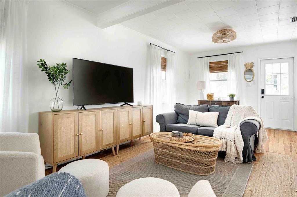 A living room features a large television on a cane cabinet, a sofa, and armchairs — 315 HOPE STREET, TARPON SPRINGS, FL