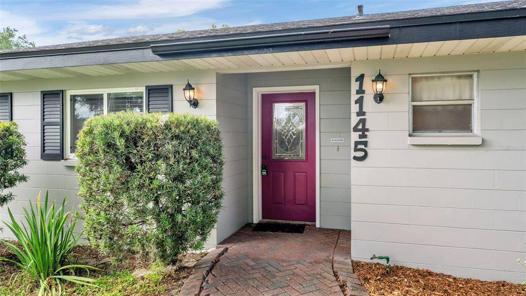 A front exterior view shows a purple door, house numbers, and a brick walkway — 1145 E GEORGE STREET, BARTOW, FL