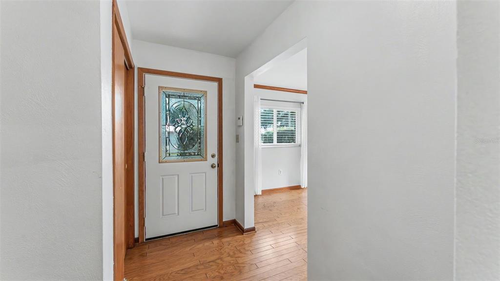 An entryway features a white front door with a decorative glass insert and wood flooring — 1145 E GEORGE STREET, BARTOW, FL