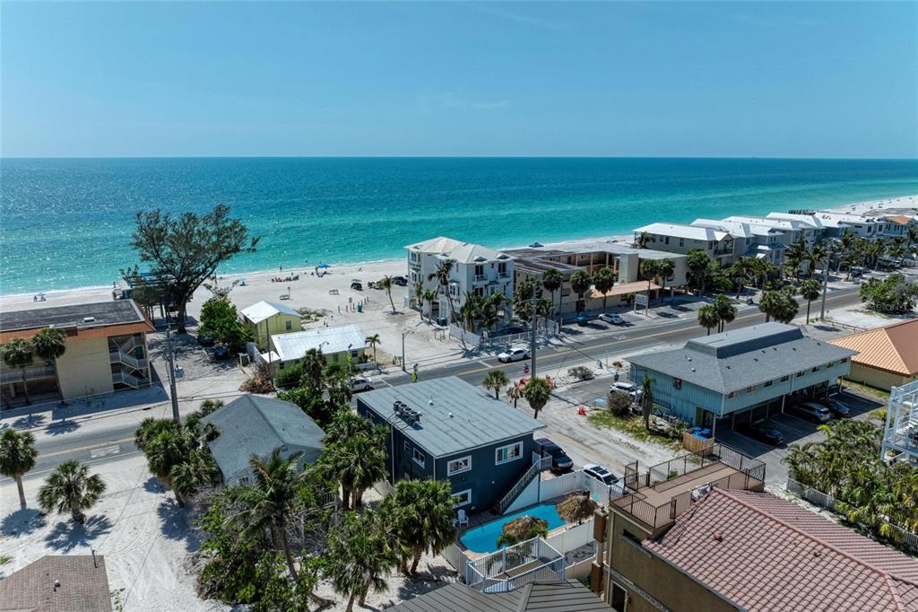 An aerial view of a coastal neighborhood featuring houses, a swimming pool, and a beach — 101 25TH STREET N UNIT 1, BRADENTON BEACH, FL