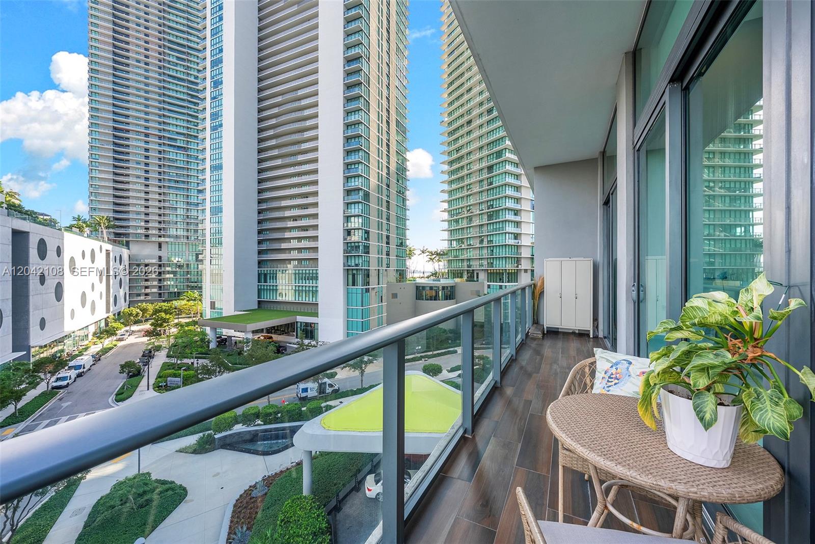 A balcony with a small table, a potted plant, and views of surrounding high-rise buildings — 501 NE 31st St # 401, Miami FL 33137, MIAMI, FL
