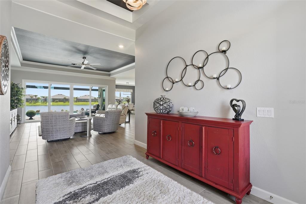 A red sideboard sits in a foyer with tile floors, leading to a living area — 15357 RIVER BIRCH COURT, PUNTA GORDA, FL