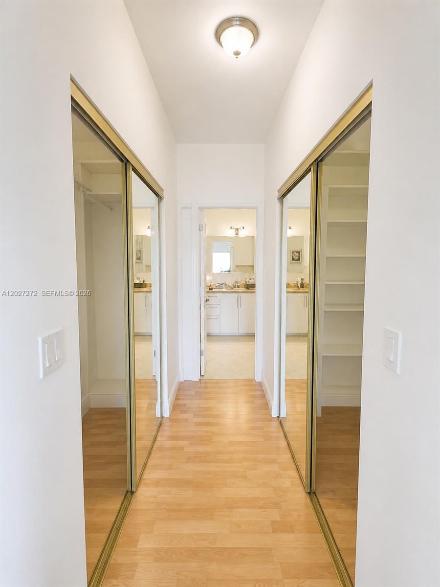 A hallway features mirrored sliding closet doors on both sides and leads to a bathroom — 1101 NE 2nd St, Hallandale Beach FL 33009, HALLANDALE BEACH, FL