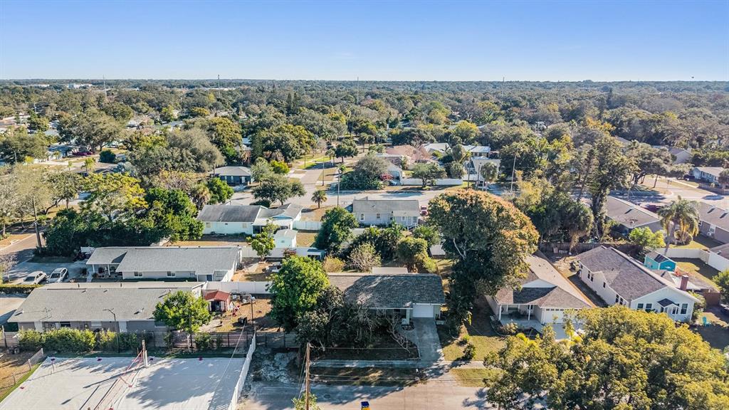 An aerial view shows several single-story residential houses surrounded by trees and paved streets — 2025 PLAZA DOLORES, CLEARWATER, FL